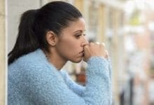 joven triste mirando desde un balcón