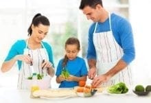 Padres y niños pequeños preparan comida saludable juntos en la cocina