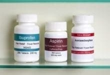 Frascos de ibuprofeno, aspirina y paracetamol en un botiquín