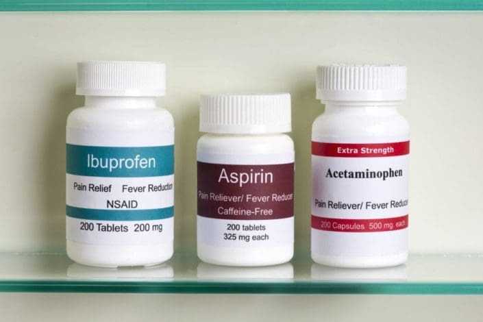 Frascos de ibuprofeno, aspirina y paracetamol en un botiquín