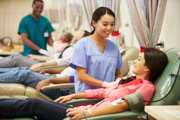 Una mujer sentada en una silla donando sangre